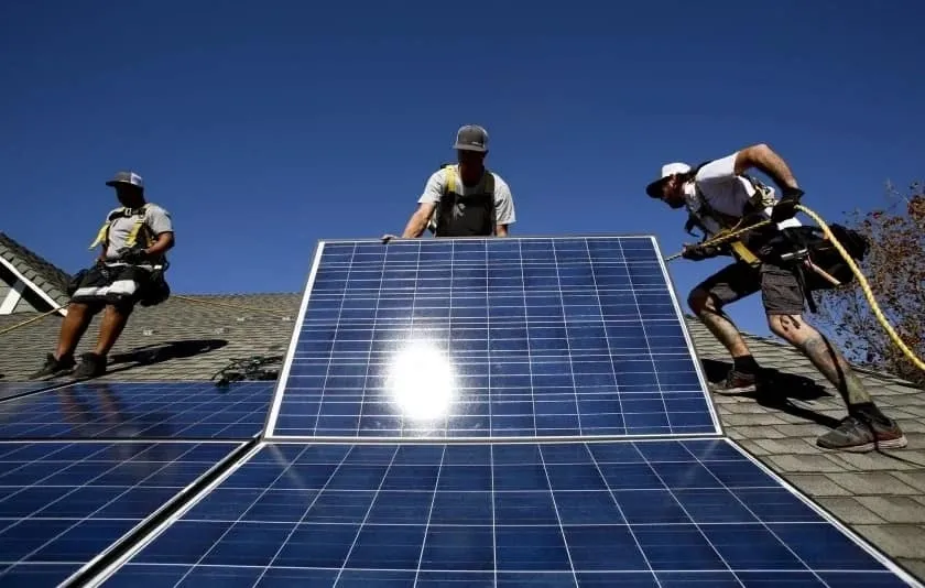 A group of men working on solar panels.